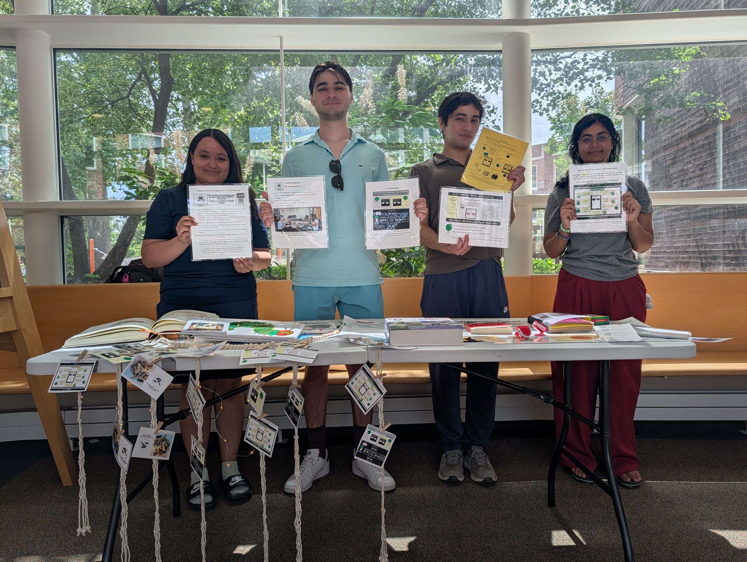 An image of the fours team members holding advserting materials behind a desk
